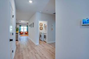 a living room with a hallway with a washer and dryer at Citrus Cottage: Comfy - Hwy 10 - Peaceful Retreat in Tallahassee