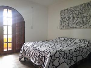 een slaapkamer met een bed en een schilderij aan de muur bij Departamento Brasil in Lunlunta