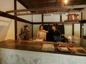 a group of three people standing behind a counter at Gonomori main building - Vacation STAY 24252v in Nagano