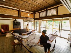 um grupo de pessoas sentadas em redes num quarto em Gonomori main building - Vacation STAY 24252v em Nagano
