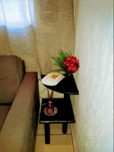 uma pequena mesa com um vaso de flores em CantinhoDaAline2-Expo-Aeroporto-18981391712 em Araçatuba