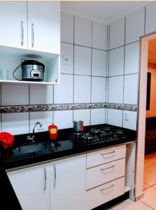 uma cozinha branca com um fogão e um lavatório em CantinhoDaAline2-Expo-Aeroporto-18981391712 em Araçatuba