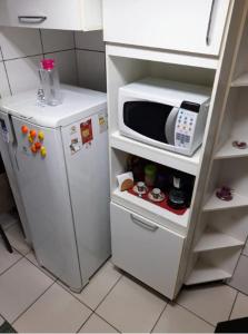 um micro-ondas sentado em cima de um frigorífico em Cantinho Da Aline 2 em Araçatuba