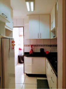 uma cozinha com armários brancos e um frigorífico em CantinhoDaAline2-Expo-Aeroporto-18981391712 em Araçatuba