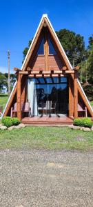 Cabaña de madera con ventana grande en un campo en Recanto do lago, en Itati