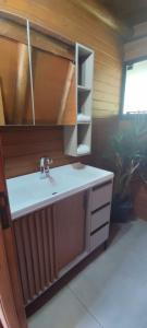 y baño con lavabo y estante. en Recanto do lago, en Itati