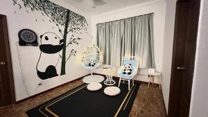 uma sala para crianças com um berçário panda com uma mesa e cadeiras em PandaHomestay28 em Skudai