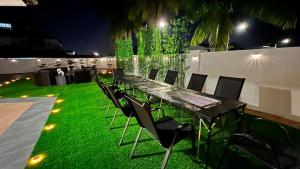 a long table and chairs on a lawn at night at PandaHomestay28 in Skudai
