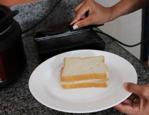 a slice of sandwich on a white plate on a counter at Hotel Mandacaru in Piranhas