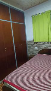 - une chambre avec un lit et un rideau vert dans l'établissement Casa para hasta 6 personas, à Santa Teresita