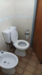 La salle de bains est pourvue de toilettes blanches et d'un lavabo. dans l'établissement Casa para hasta 6 personas, à Santa Teresita