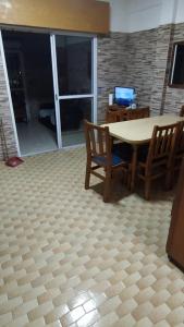 a dining room with a table and chairs and a television at Casa para hasta 6 personas in Santa Teresita