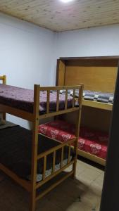 two bunk beds in a room with purple sheets at Casa para hasta 6 personas in Santa Teresita