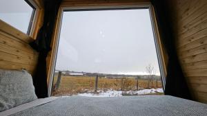 a bedroom with a large window looking out at a field at Auberge de nos Aieux in Les Éboulements