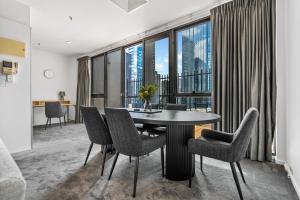ein Esszimmer mit einem Tisch und Stühlen sowie einem großen Fenster in der Unterkunft Family Friendly Getaway on Flinders Street in Melbourne