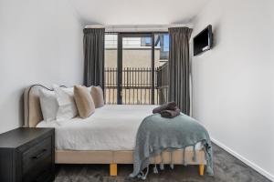 ein Schlafzimmer mit einem Bett und einem großen Fenster in der Unterkunft Family Friendly Getaway on Flinders Street in Melbourne