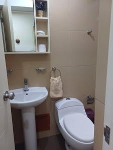 a bathroom with a white toilet and a sink at Habitación acogedora Aramburú in Lima