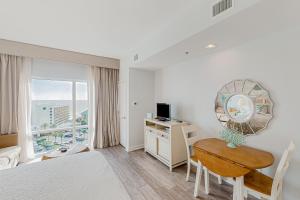 a bedroom with a bed and a desk with a mirror at Luau 6834 in Destin