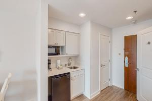 a kitchen with white cabinets and a sink at Luau 6834 in Destin