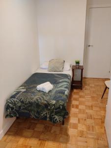 a small bedroom with a bed and a wooden floor at Habitacion confort en Chamartín in Madrid