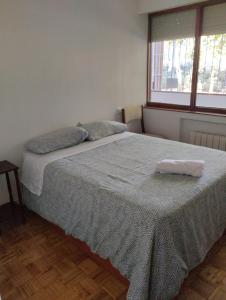 1 dormitorio con 1 cama con manta y ventana en Habitacion confort en Chamartín, en Madrid