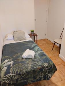 a bedroom with a bed with two towels on it at Habitacion confort en Chamartín in Madrid