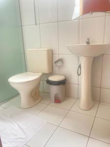 a bathroom with a toilet and a sink at Pousada Lirio do Vale in Cachoeira Paulista