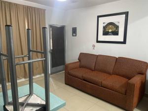 un soggiorno con divano marrone in una camera di Loft hermoso con estacionamiento gratuito a Monterrey