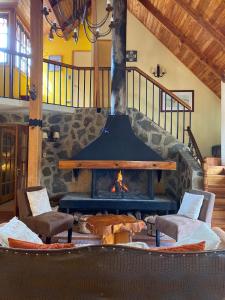 a fireplace in a room with two chairs and a table at Refugio Invernalia in Las Trancas