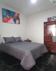 a bedroom with a bed and a wooden dresser at Hermoso apartamento Duplex in Guaduas