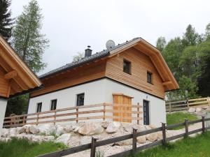 ein Haus mit einem Holzdach und einem Zaun in der Unterkunft Chalet in Bad Kleinkirchheim with sauna in Bad Kleinkirchheim