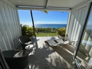 a screened in porch with a view of the ocean at Moana Lodge in Saint-François