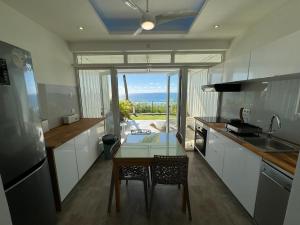 cocina con mesa y vistas al océano en Moana Lodge, en Saint-François