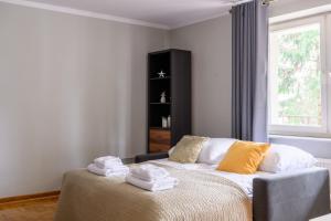 ein Schlafzimmer mit einem Bett mit Handtüchern darauf in der Unterkunft Bella Casa Premium Apartment - Biesiadna - Warszawa in Warschau