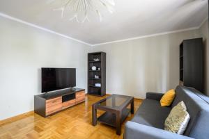 ein Wohnzimmer mit einem Sofa und einem Flachbild-TV in der Unterkunft Bella Casa Premium Apartment - Biesiadna - Warszawa in Warschau