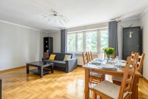 ein Wohnzimmer mit einem Tisch und einem Sofa in der Unterkunft Bella Casa Premium Apartment - Biesiadna - Warszawa in Warschau