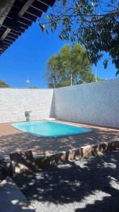 une petite piscine bleue à côté d'un mur dans l'établissement Beach House Guriri - Casa de temporada, à São Mateus