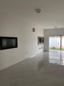 Cette chambre vide est dotée de murs blancs et de carrelage. dans l'établissement Beach House Guriri - Casa de temporada, à São Mateus