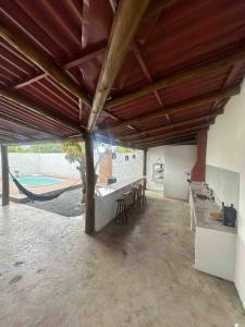 d'une terrasse avec un hamac, une table et des chaises. dans l'établissement Beach House Guriri - Casa de temporada, à São Mateus