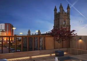 a building with a tower and a tree on a balcony at Central Manchester Duplex - Balcony - Roof Terrace - Parking in Manchester