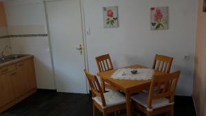 a kitchen with a wooden table with four chairs at Apartement Victoria in Swisttal +11 photos