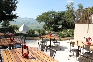 a patio with tables and chairs with mountains in the background at Pyramids Motel in Van Reenen