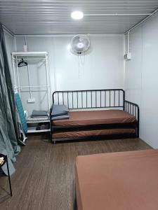 Habitación pequeña con 2 camas y ventilador. en Ghumoh Safar (Bed,Pool & Cafe), en Kuala Kangsar
