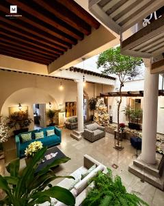 uma sala de estar exterior com sofás azuis e plantas em M Hoteles Concepto em Morelia