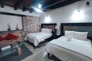 モレリアにあるM Hoteles Conceptoのベッド2台とソファが備わるホテルルームです。