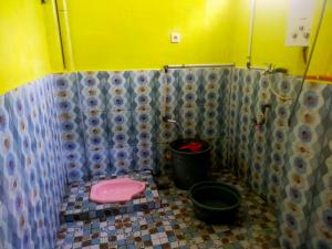 La salle de bains est pourvue de toilettes roses et d'un seau. dans l'établissement Penginapan sweety homestays & Villas, à Ciwidey
