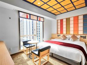 a bedroom with a bed and a table and chairs at Daiwa Roynet Hotel KANAZAWA-MIYABI in Kanazawa