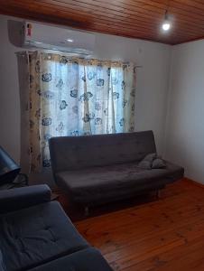 un sofá en una sala de estar con ventana en Aconchego en Pântano Grande