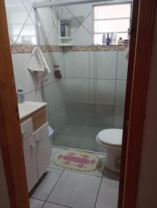 een badkamer met een douche, een wastafel en een toilet bij Aconchego in Pântano Grande