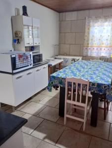 uma cozinha com uma mesa e uma cozinha com electrodomésticos brancos em Aconchego em Pântano Grande